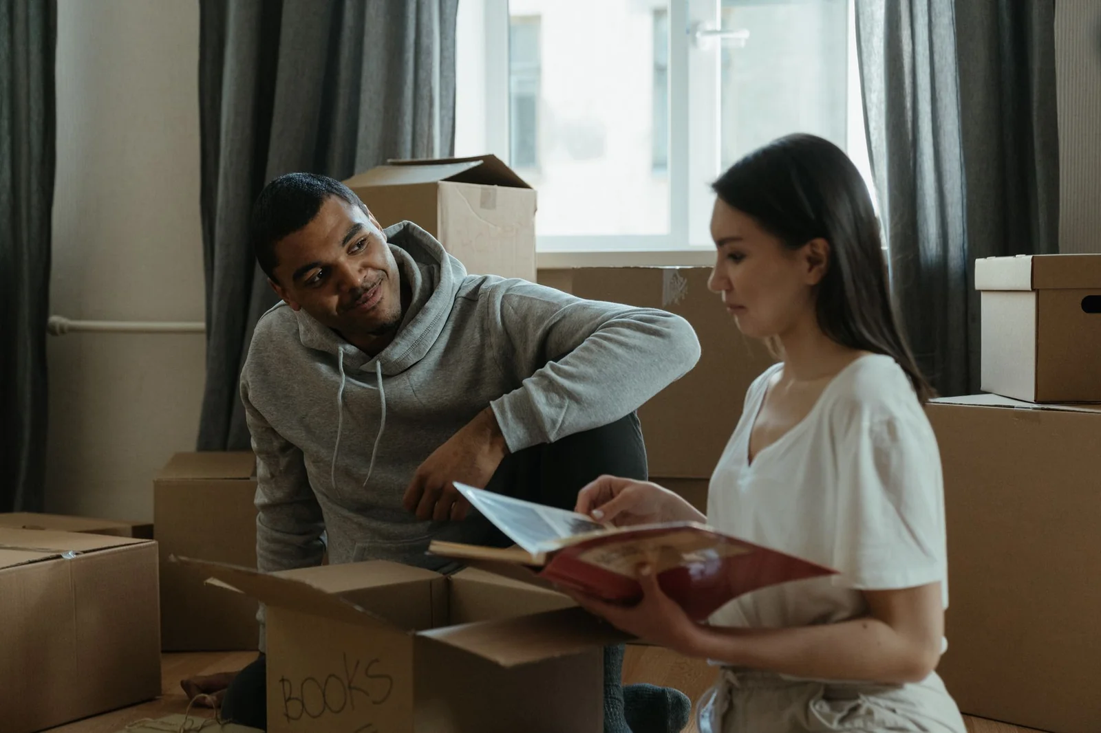Couple comparant des devis de déménagement au milieu de cartons