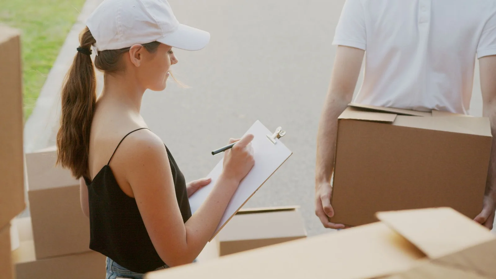 Déménageur remplissant un devis avec un client devant des cartons